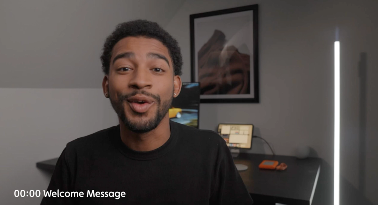Creator speaking to camera in a talking-head video, desk lamp behind him