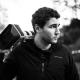 Black-and-white photo of a videographer carrying a cinema camera on his shoulder