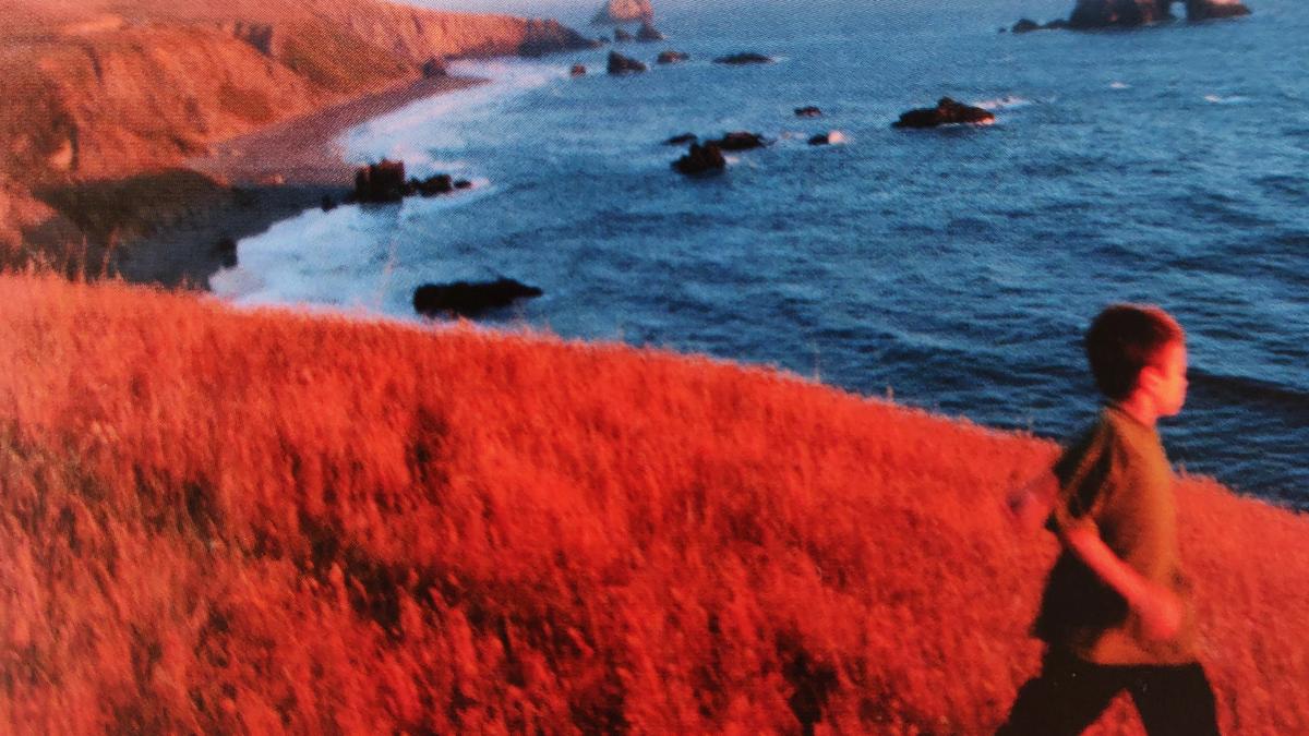 Cover detail of September showing a boy running through a field