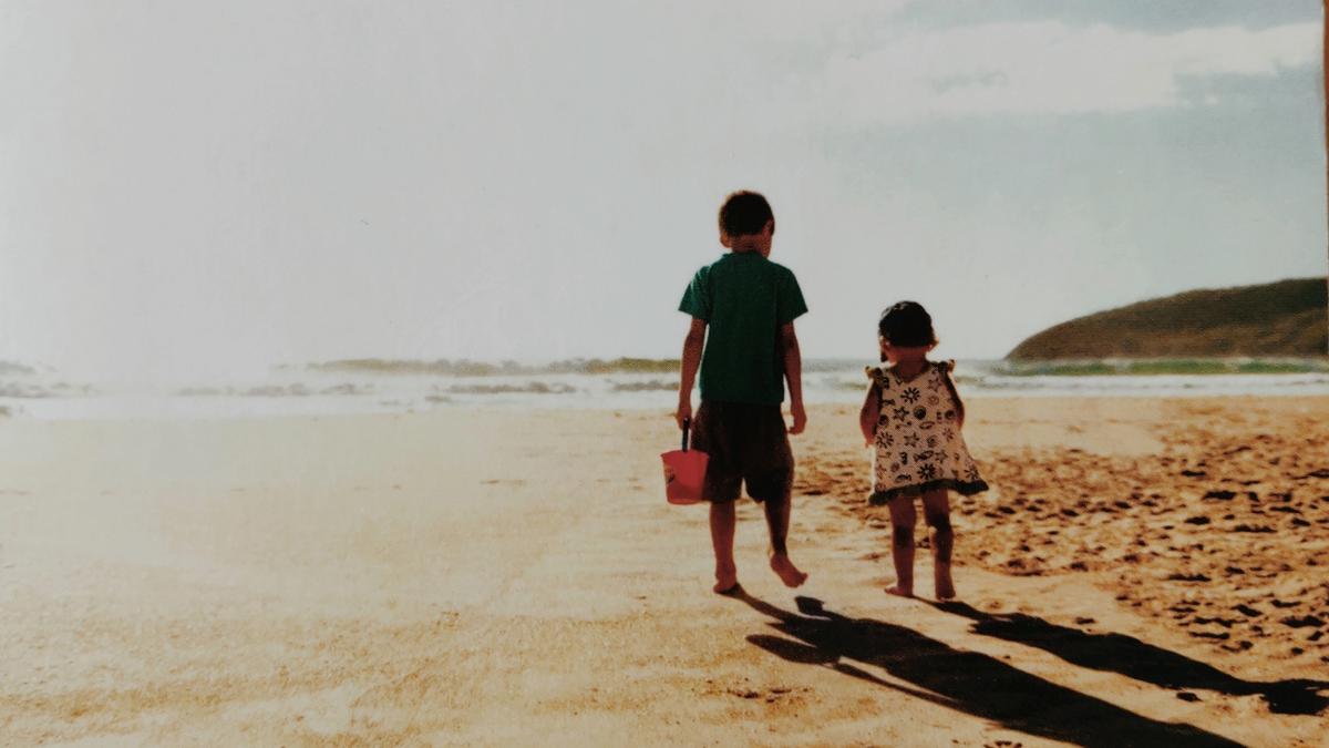 Cover detail from The Shell Seekers by Rosamunde Pilcher showing two children walking on a sandy beach