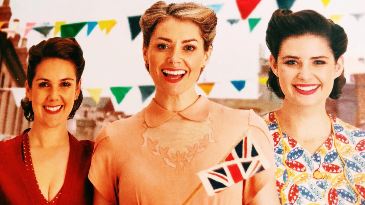 Cover detail from Three Cheers for the Shipyard Girls showing 3 women in 1940s dress waving a flag