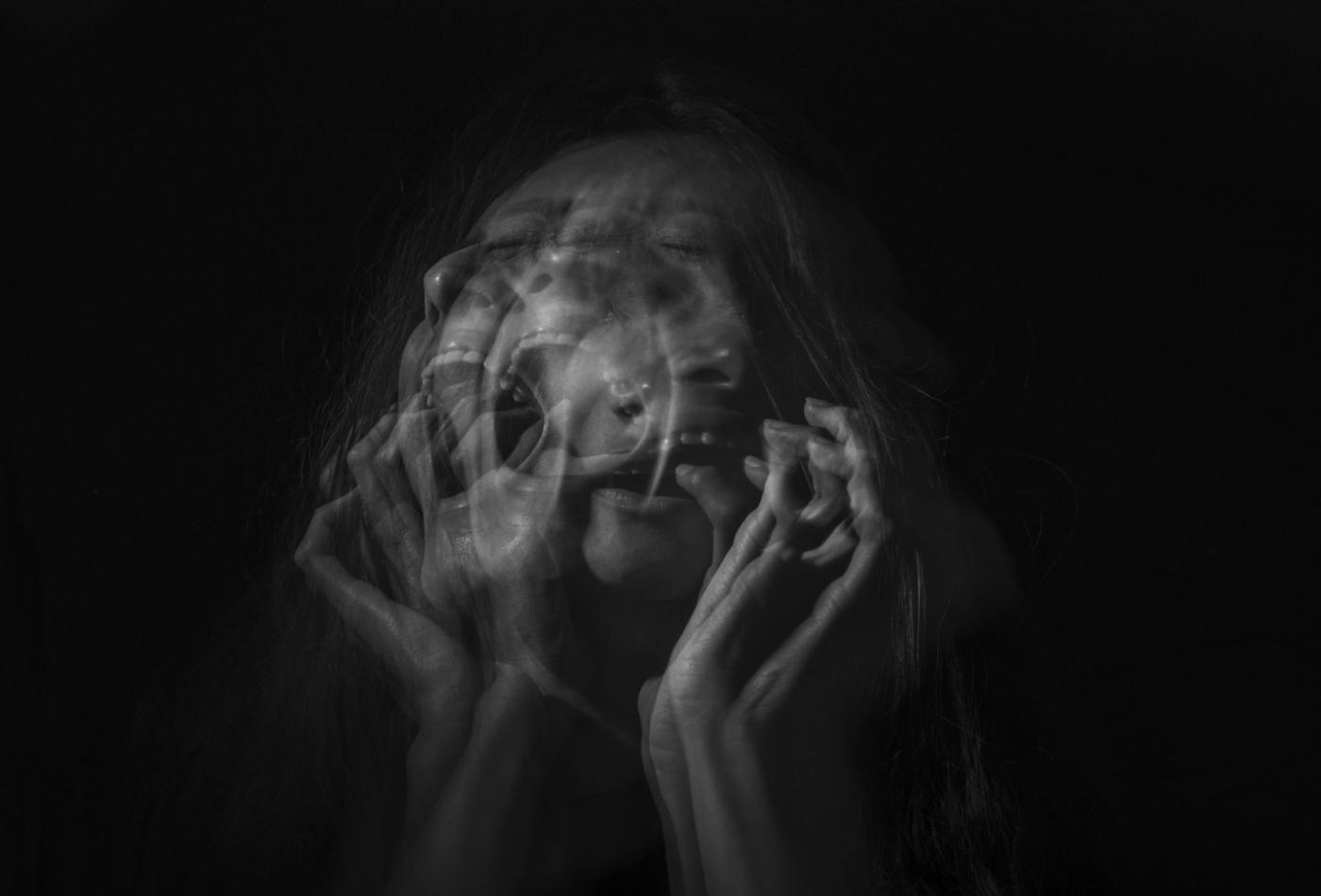 A woman screaming against a black background