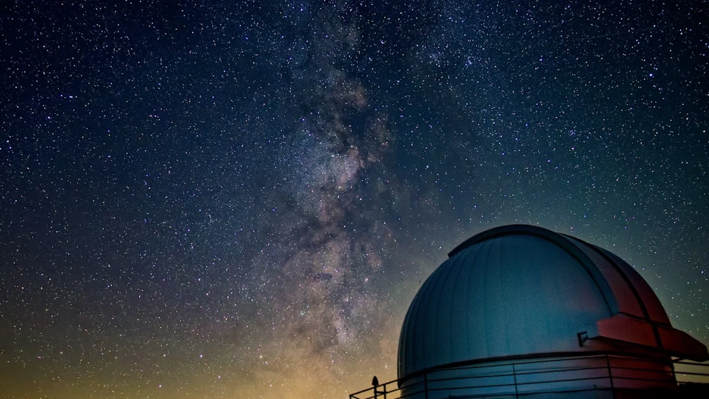 Astronomical observatory dome under a starry sky with the Milky Way.