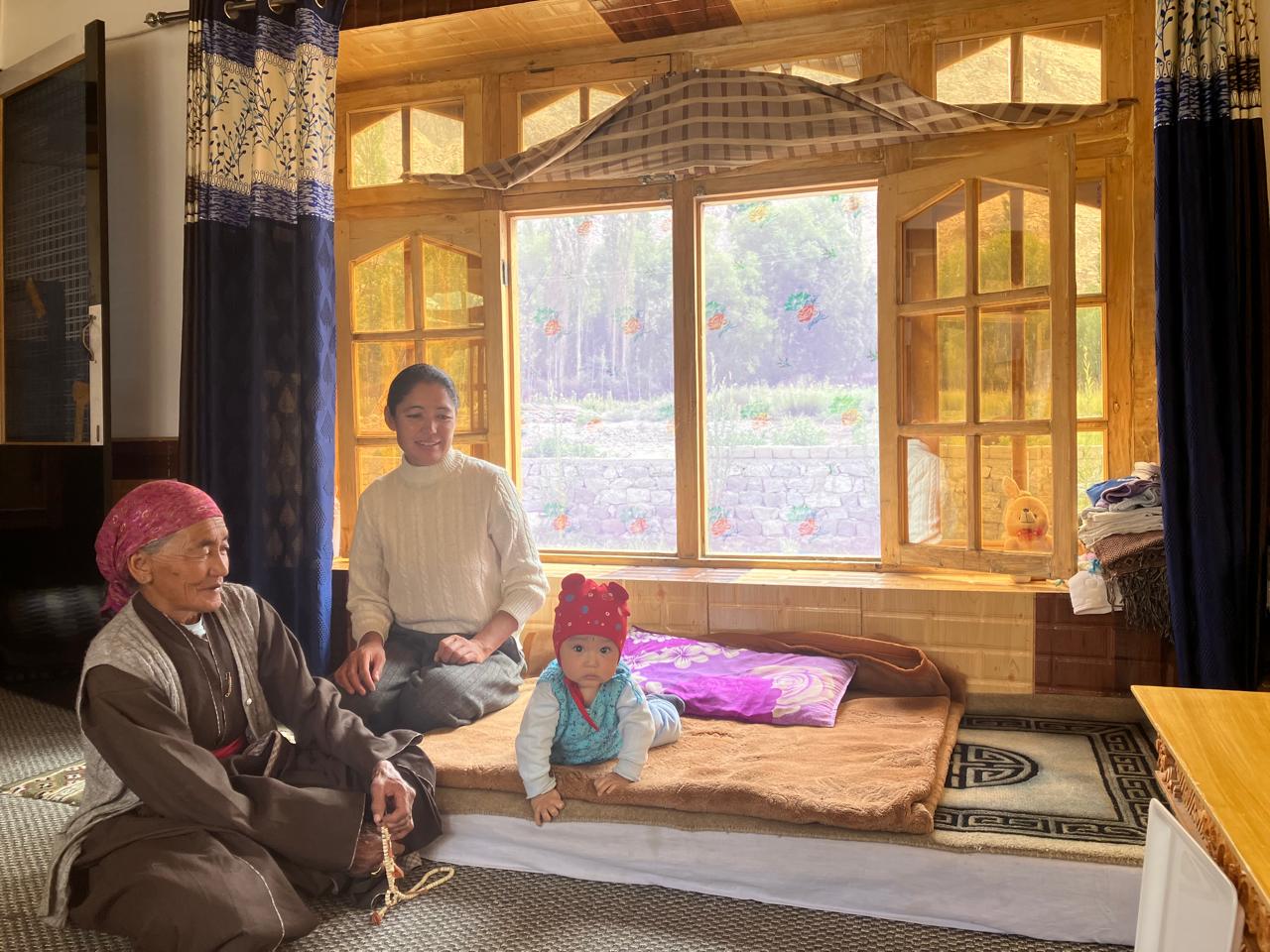 Portrait of an older woman wearing traditional headwear adorned with turquoise and large fur earflaps.