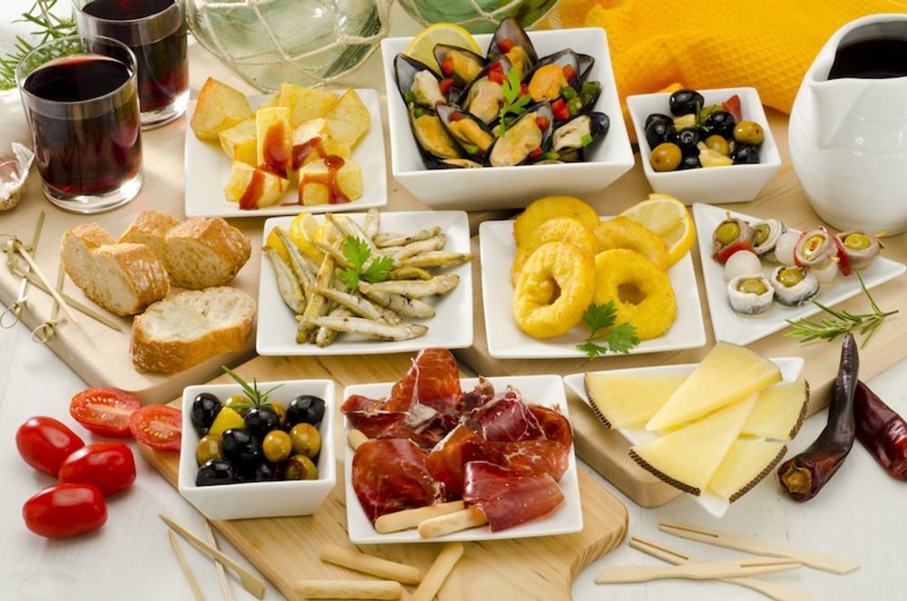 Typiska spanska tapas. Ursprungligen handlade det dock sannolikt om att vinglasen t&auml;cktes med ost eller skinka i form av ett lock, tapa.