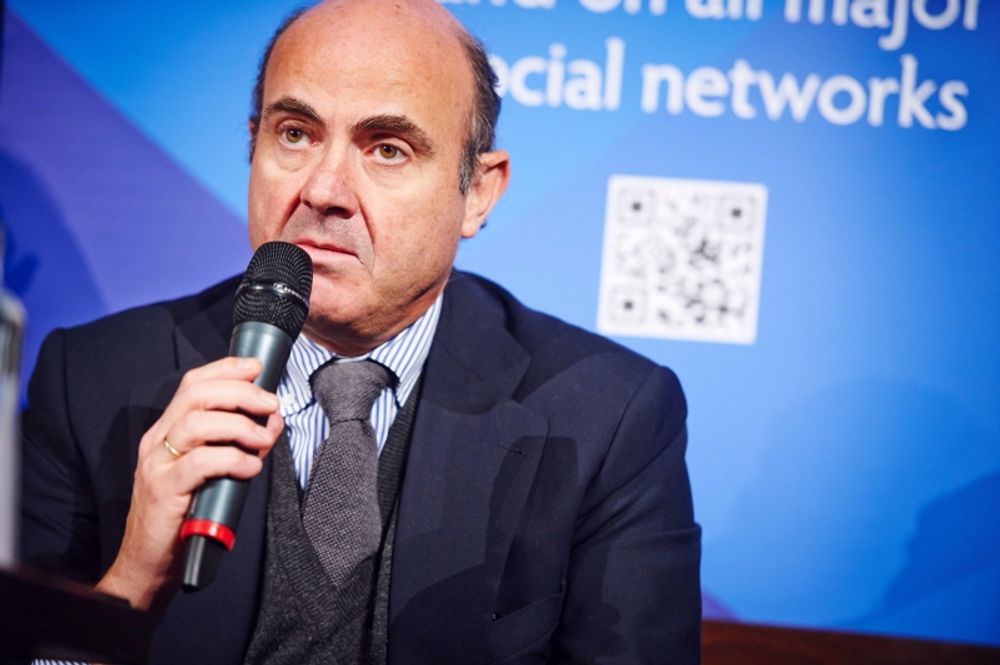 Spaniens finansminister Luis de Guindos ser mellan fingrarna med bankkollegor, men drar sig inte f&ouml;r att pressa hela Greklands befolkning.