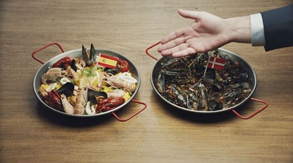 En br&auml;nd paella med dansk flagga symboliserar skandinavernas k&auml;nslighet f&ouml;r den spanska solen.