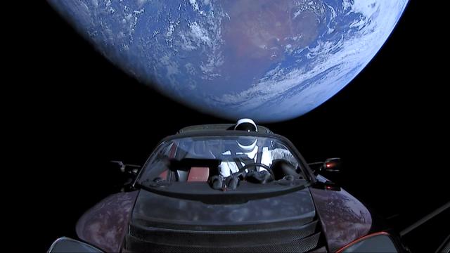 Tesla Roadster et mannequin Starman avec la Terre à l’arrière-plan.