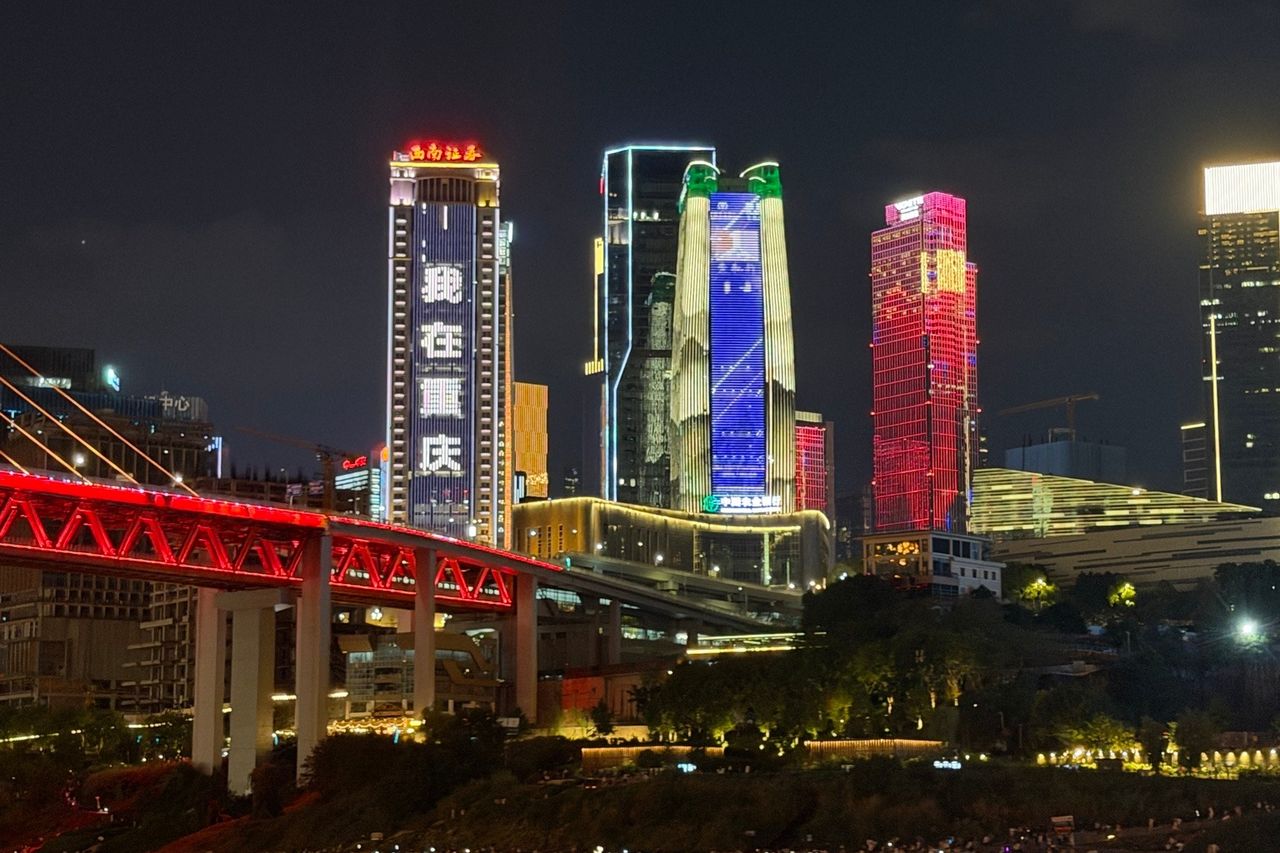 Vue nocturne de Chongqing avec infrastructures et gratte-ciel superposés.