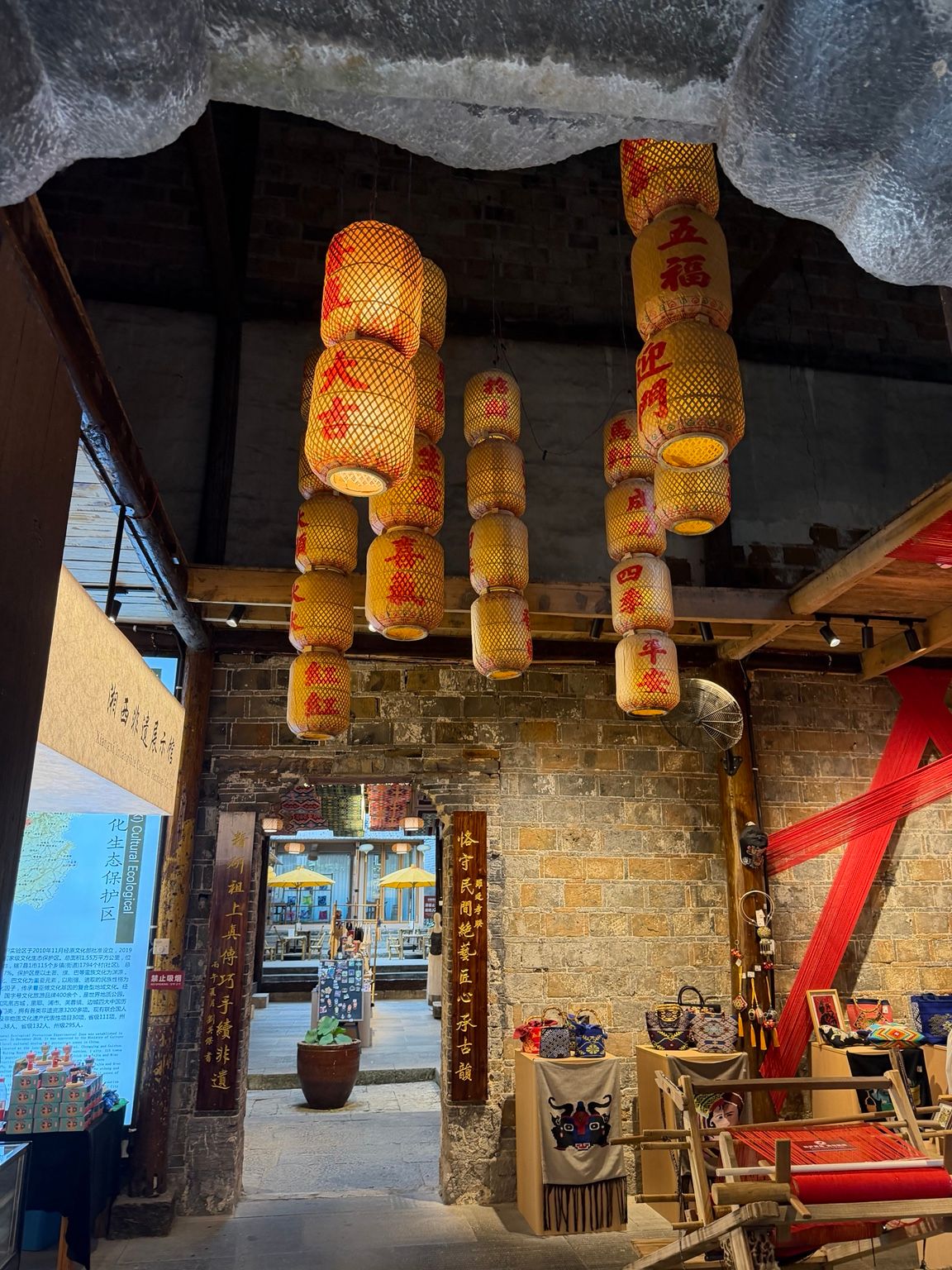 Espace intérieur de Furong Town consacré à l’artisanat, avec lanternes, textiles et objets inspirés de la culture locale.