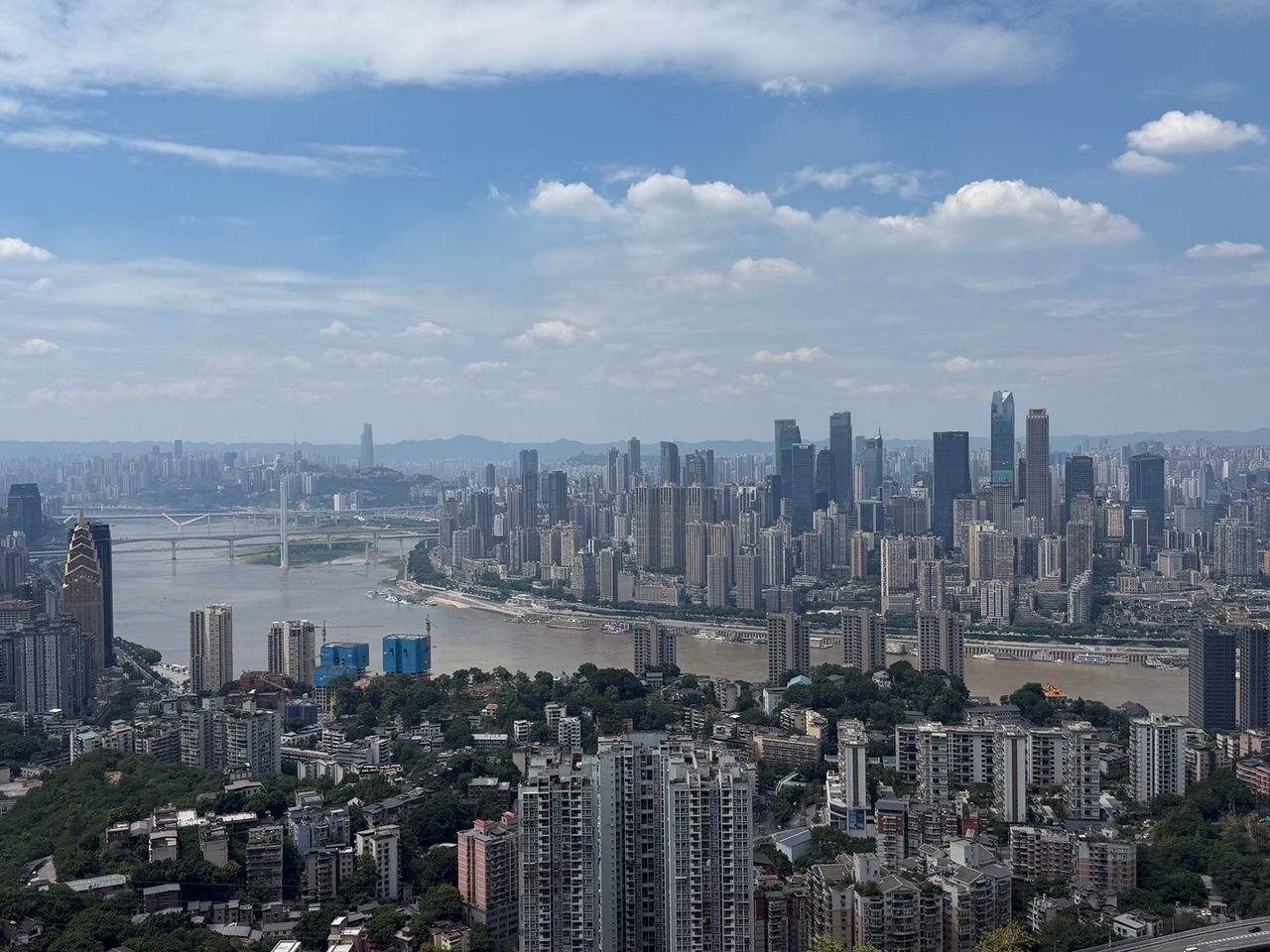 Panorama de Chongqing avec le fleuve, les ponts, les tours et plusieurs niveaux de voies urbaines.