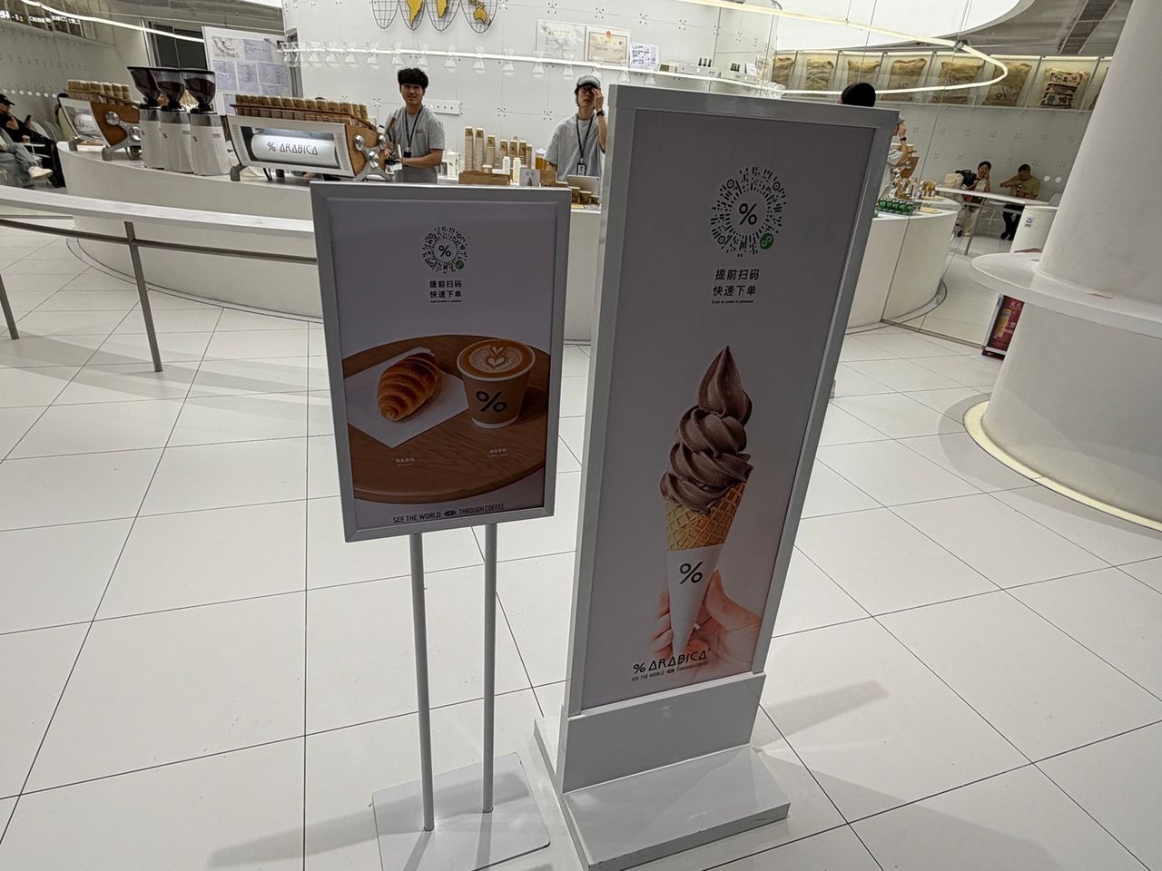Signalétique de commande par QR code dans le % Arabica de Guangzhou Baiyun, où le symbole pourcentage apparaît encore au centre du dispositif.