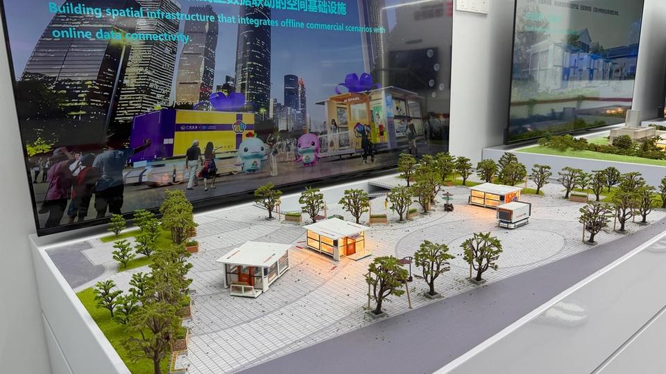 Photo terrain STORIMITIK d’une maquette urbaine FlexBot M‑SPACE montrant plusieurs modules mobiles installés sur une place.