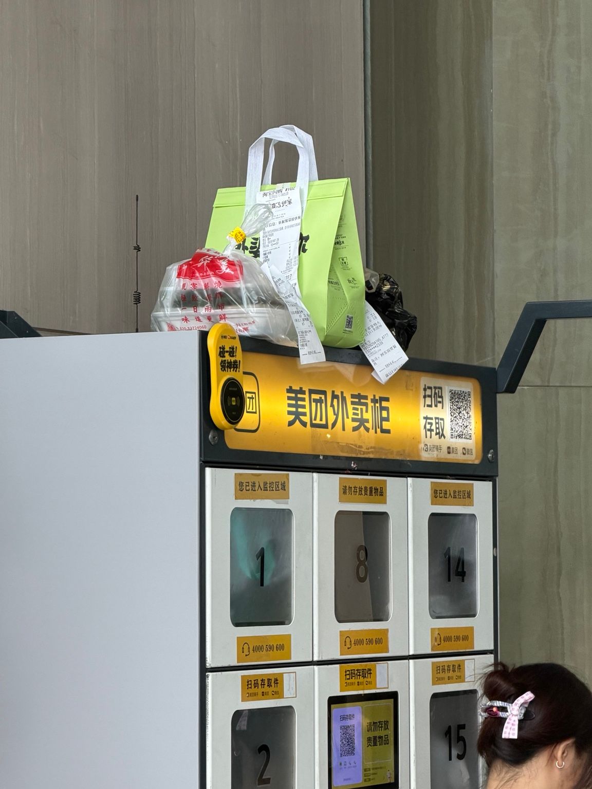 Photo terrain d’un casier de livraison Meituan et de commandes en attente à l’entrée d’un hôtel en Chine.