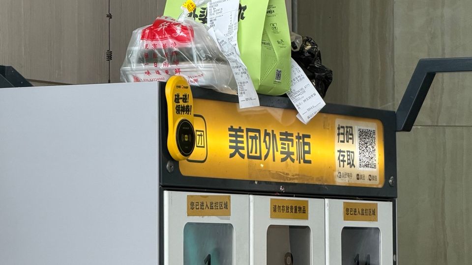 Photo terrain d’un casier de livraison Meituan et de commandes en attente à l’entrée d’un hôtel en Chine.