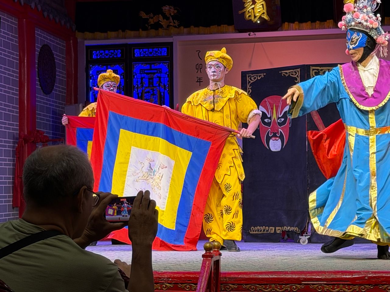 Interprètes du bian lian portant différents masques sur scène à Chengdu.