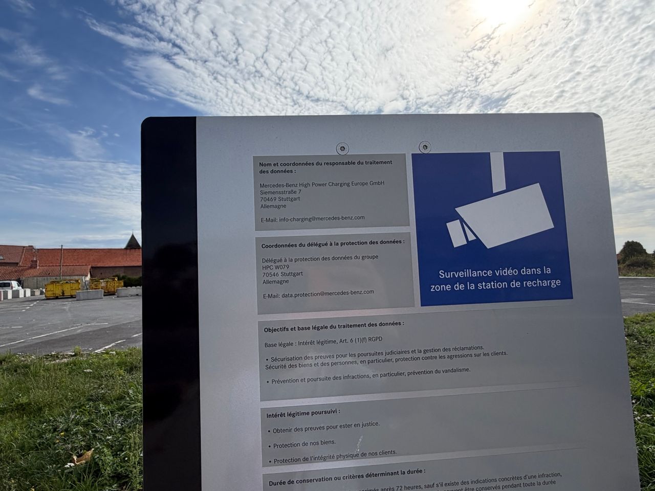 Panneau de vidéosurveillance photographié sur le site de recharge de Fresnes-lès-Montauban mentionnant Mercedes-Benz High Power Charging Europe GmbH.