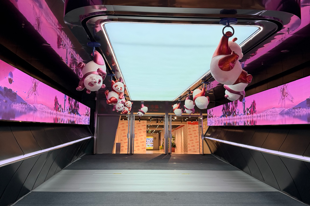 Photo terrain d’un passage immersif de Chengdu SKP avec écrans panoramiques roses et personnages suspendus.