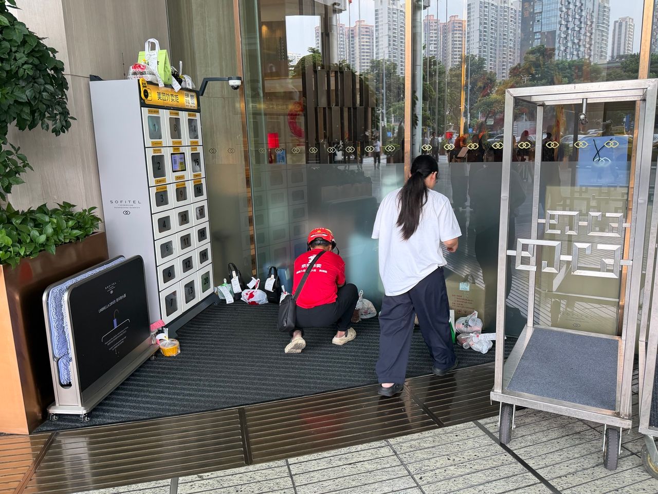 Sacs de commandes déposés temporairement dans la zone de livraison d’un bâtiment.