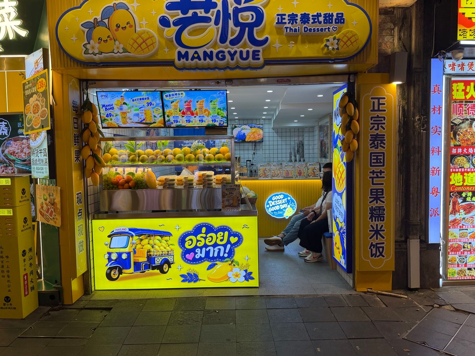 Façade réelle de MANGYUE en Chine, enseigne jaune et bleue consacrée aux desserts thaïlandais et à la mangue.