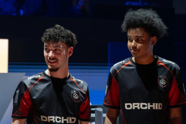 Deux membres de Team Orchid portant le maillot noir et rouge du club.