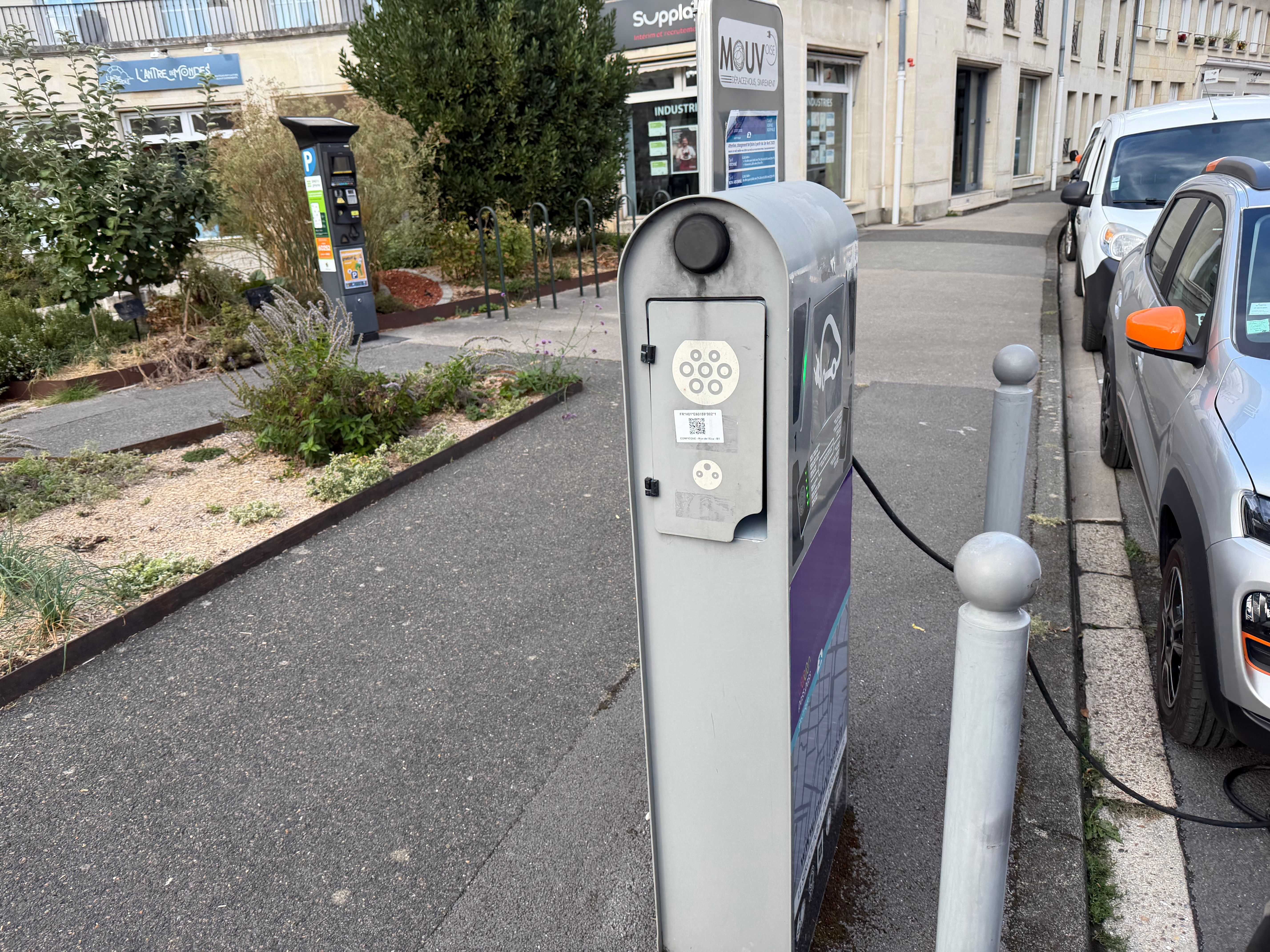 Deux voitures électriques stationnées près d’une borne Mouv’Oise.