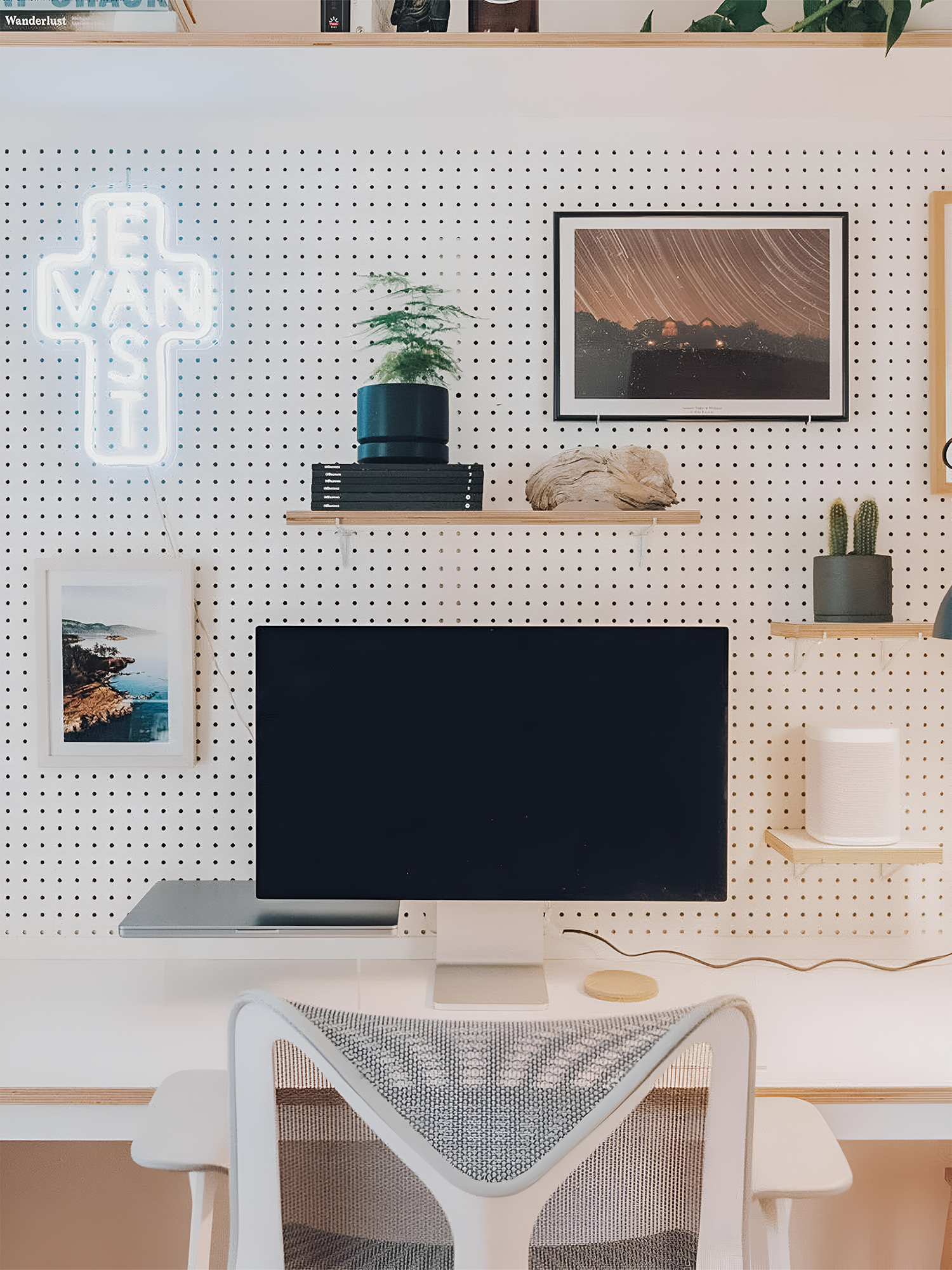 A remote office set up with a monitor, desk, chair and decor items