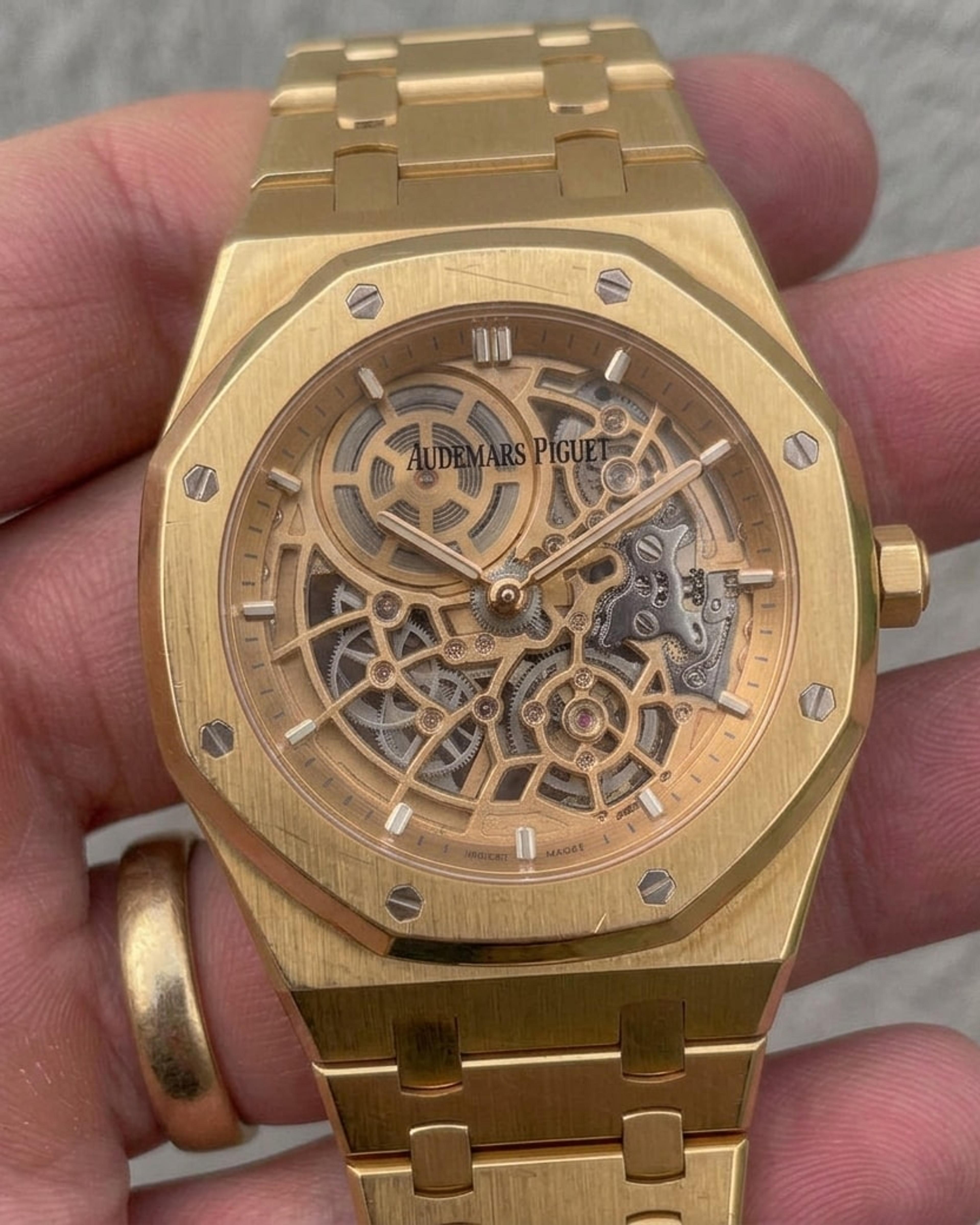 Yellow gold Audemars Piguet Royal Oak Openworked with fine scratches across the brushed bezel, held in a hand