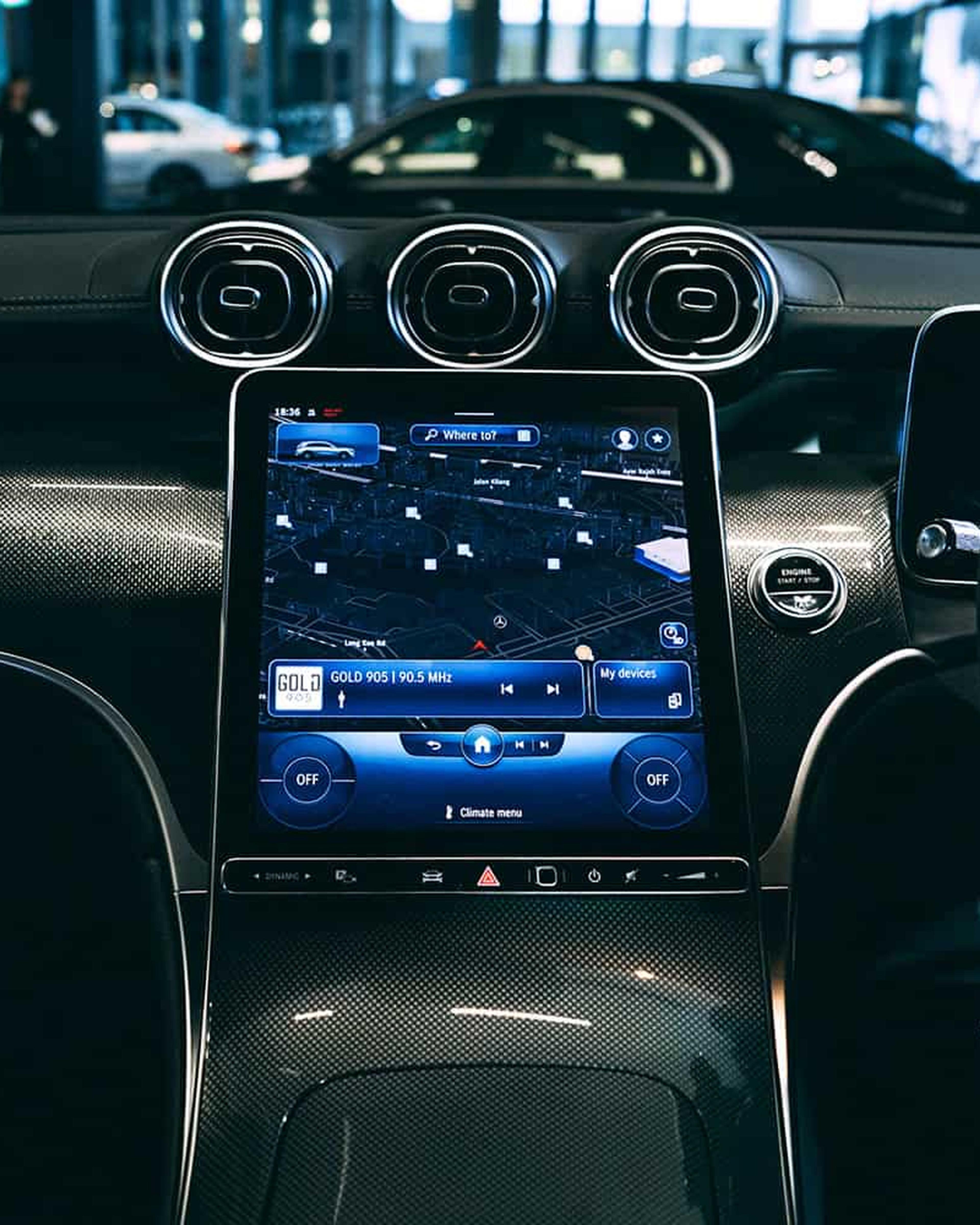 The central touchscreen of a car dashboard, beneath three round air vents