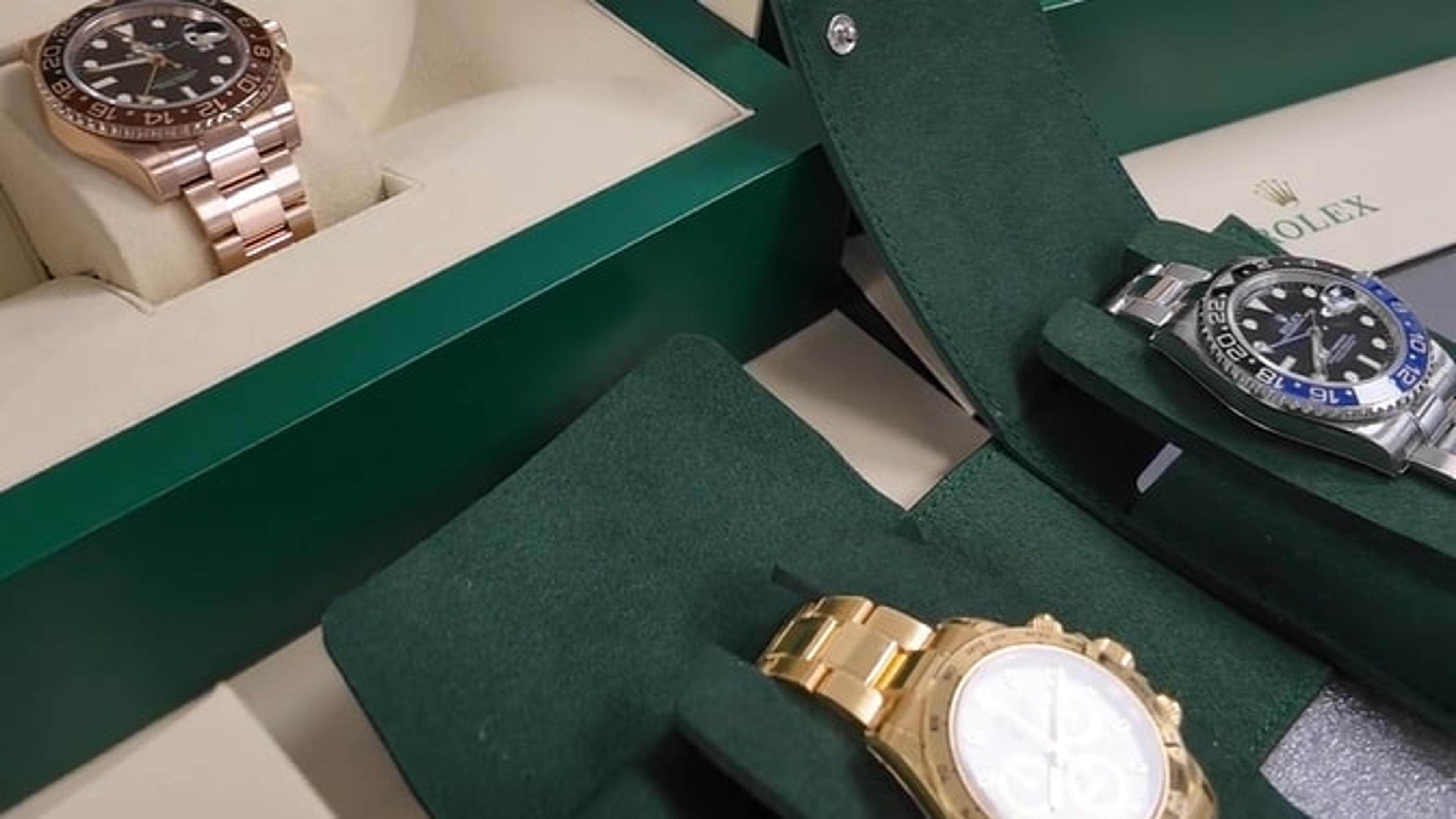 Rolex watches in their green presentation boxes and travel pouches