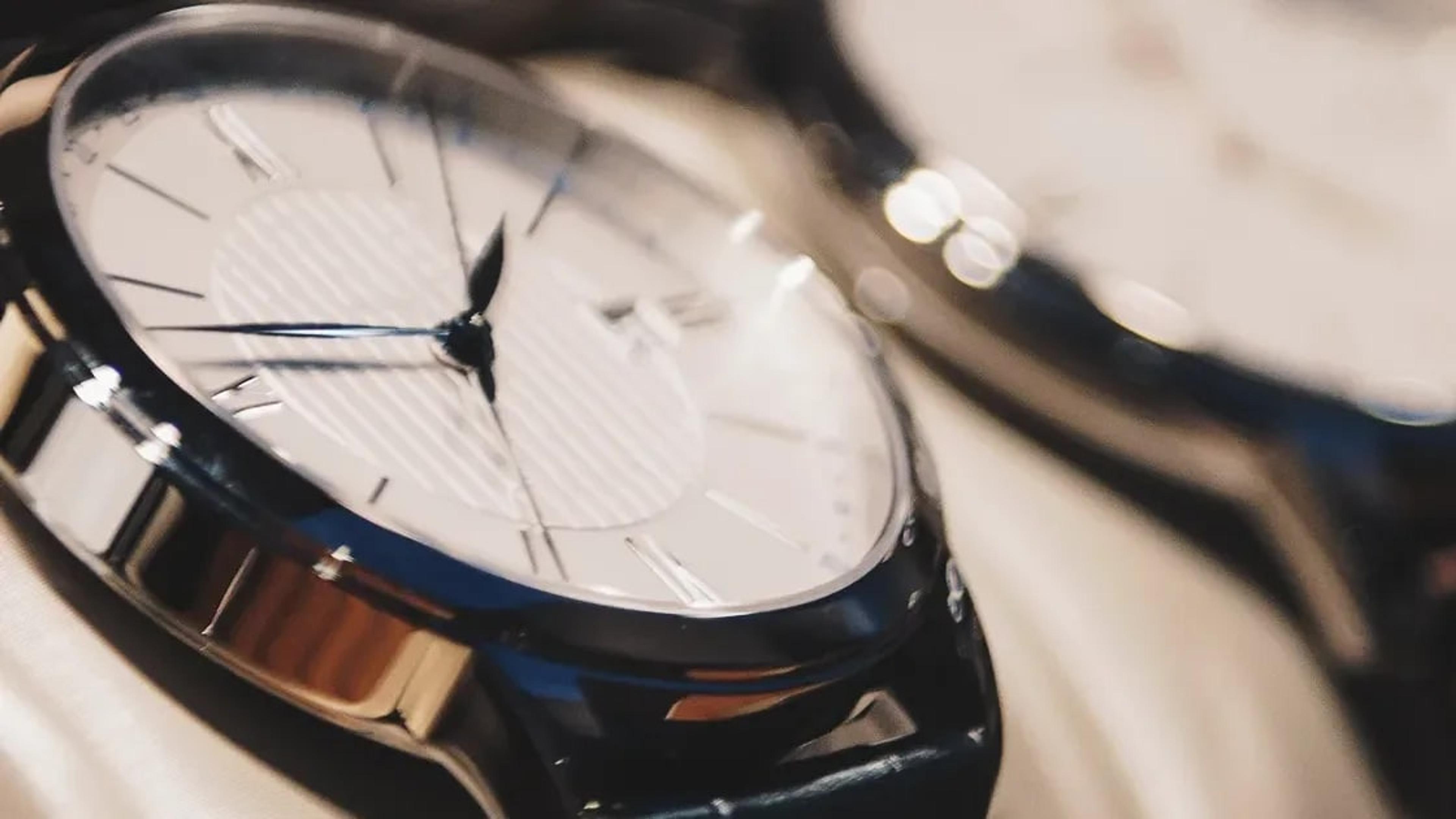 Close-up of a watch with a white dial resting on a soft cloth