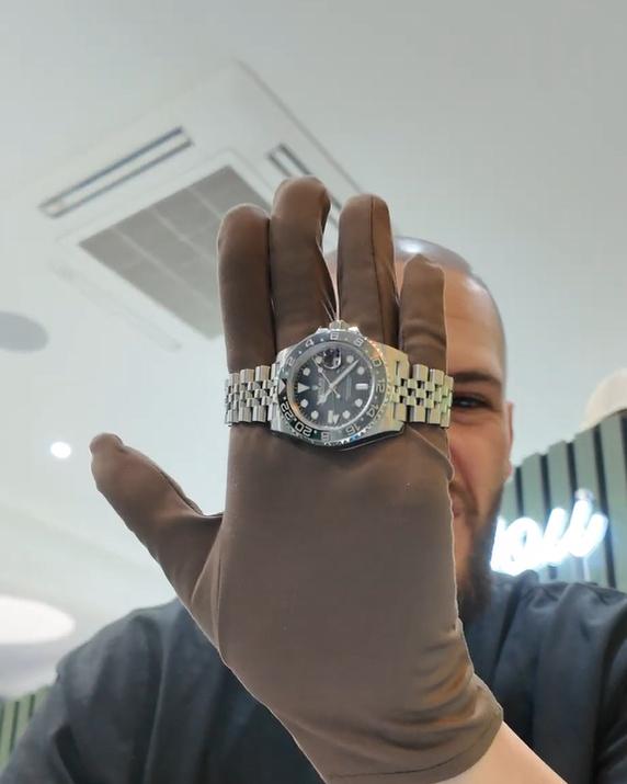 Rolex GMT-Master II on a Jubilee bracelet, held up on a gloved hand