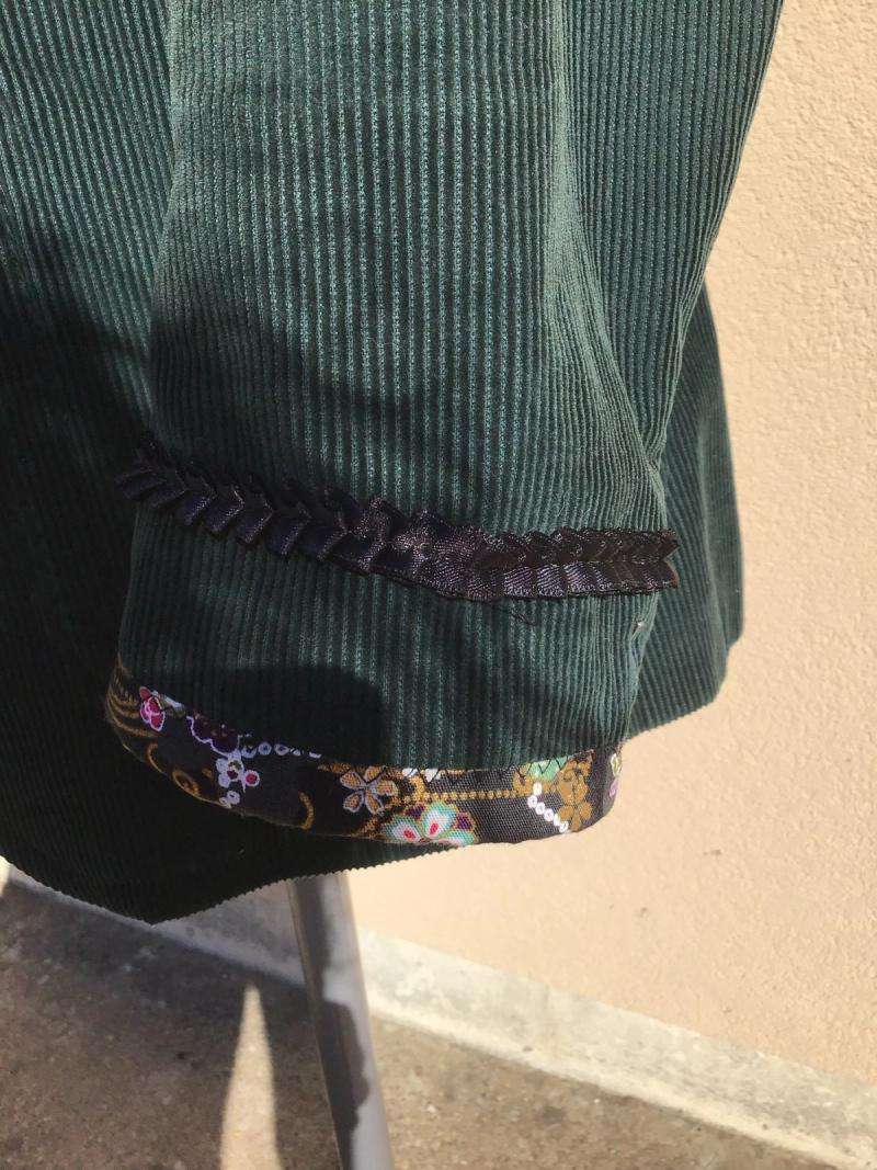 Détail du bas de manche : galon tressé et revers en tissu fleuri