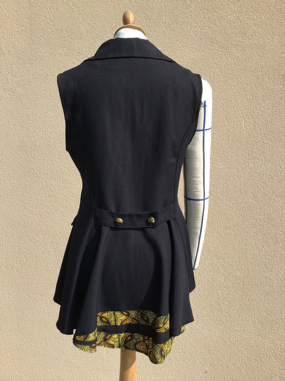 Gilet noir à basque vu de dos, doublure en wax
