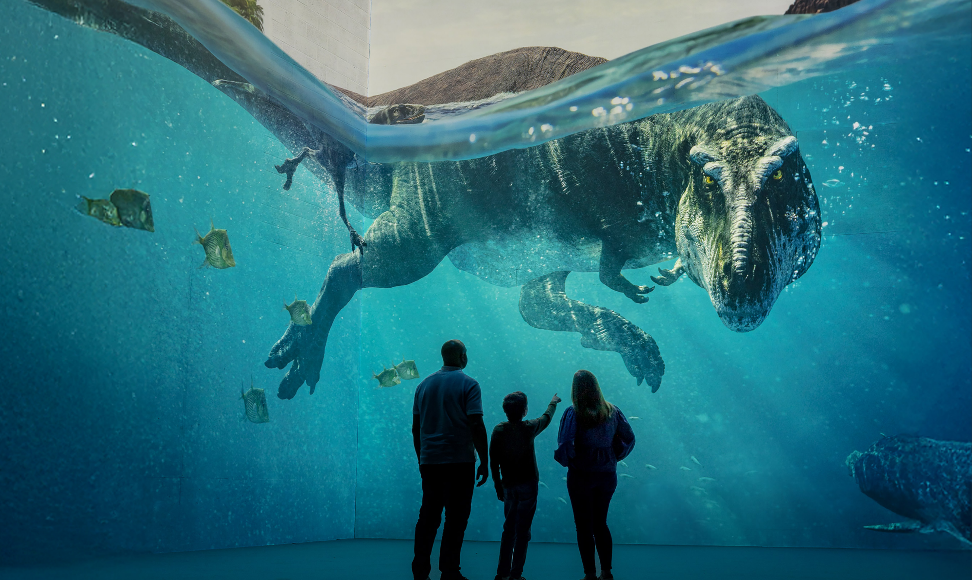 Familj tittar på t-rex som simmar i vattnet framför dem