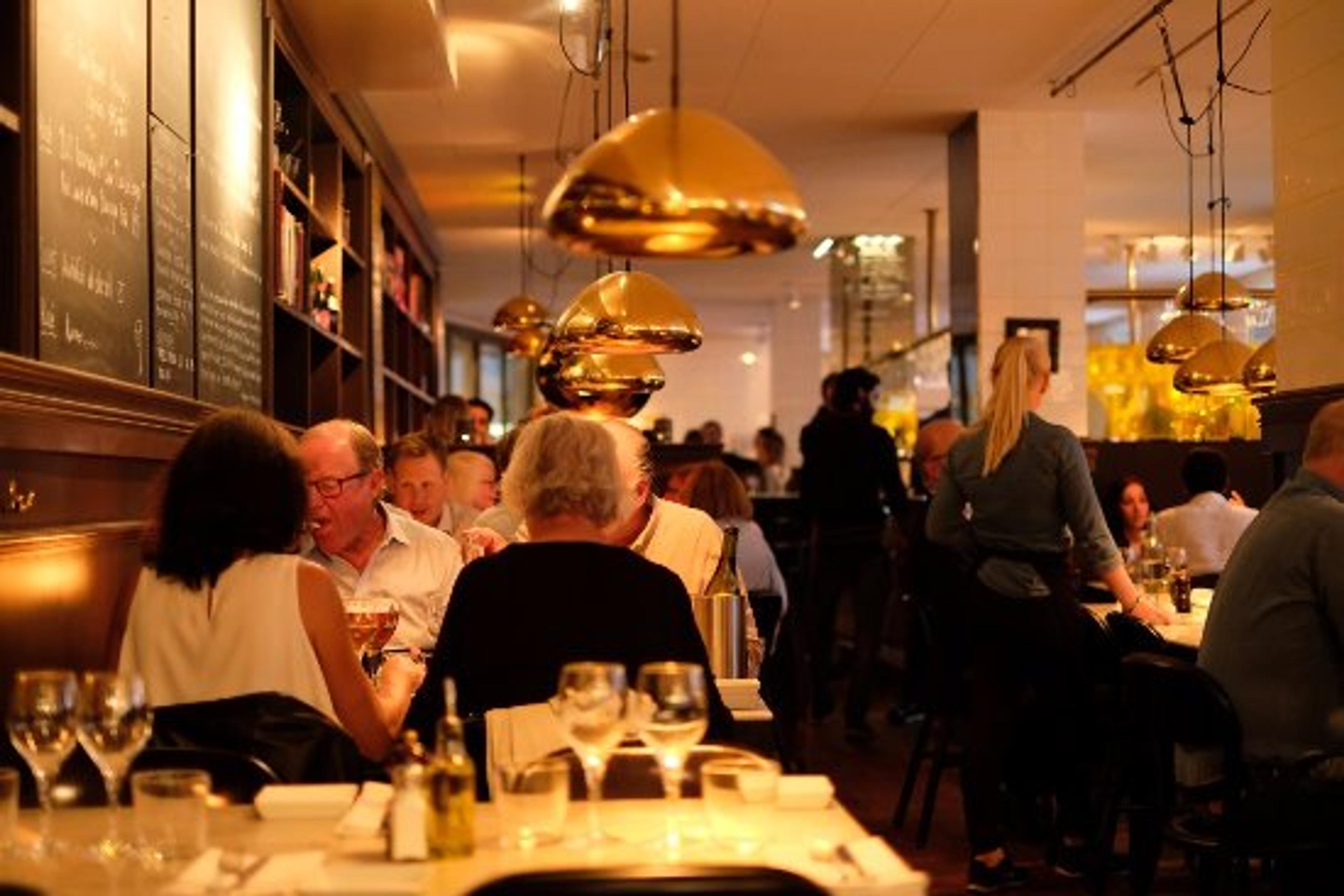 Restaurangen med fåtöljer och ett dukat bord.