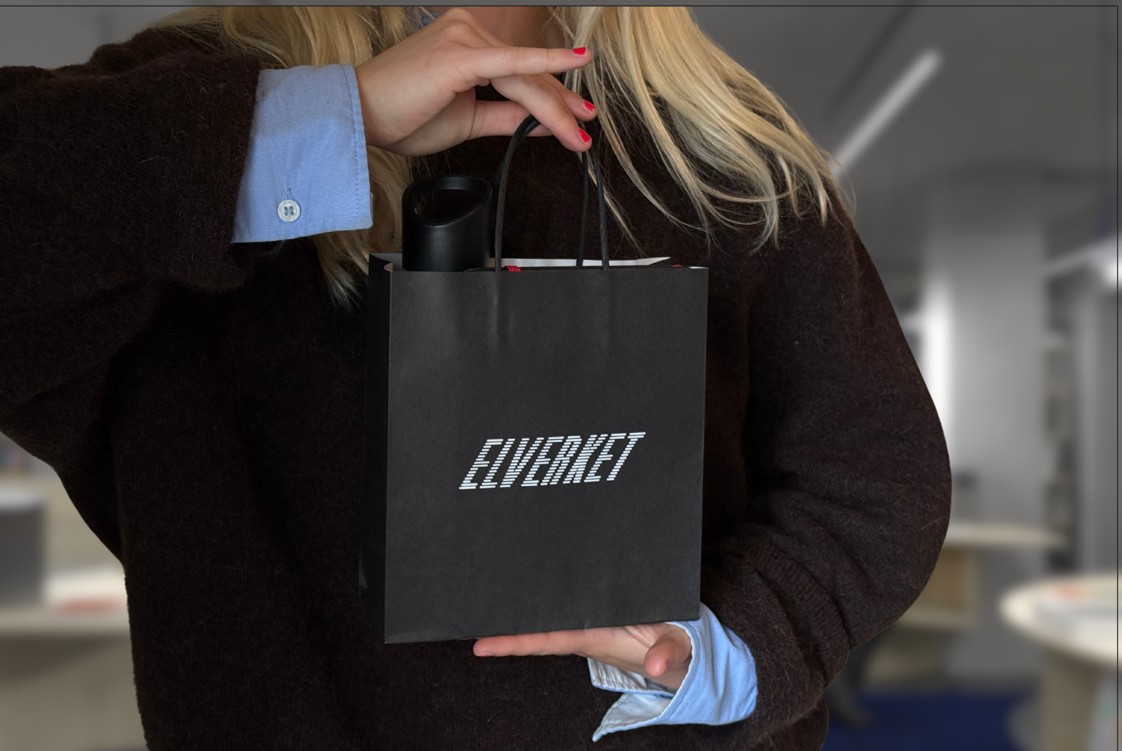 Elverkets butik med hyllor och en besökare.
