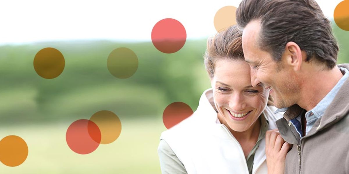 Couple sharing a warm, intimate moment outdoors, smiling and leaning close