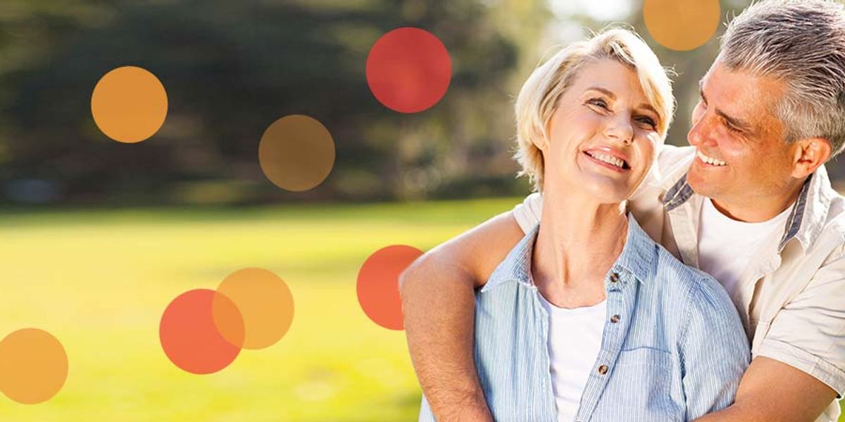 Smiling couple embracing outdoors in a sunny park