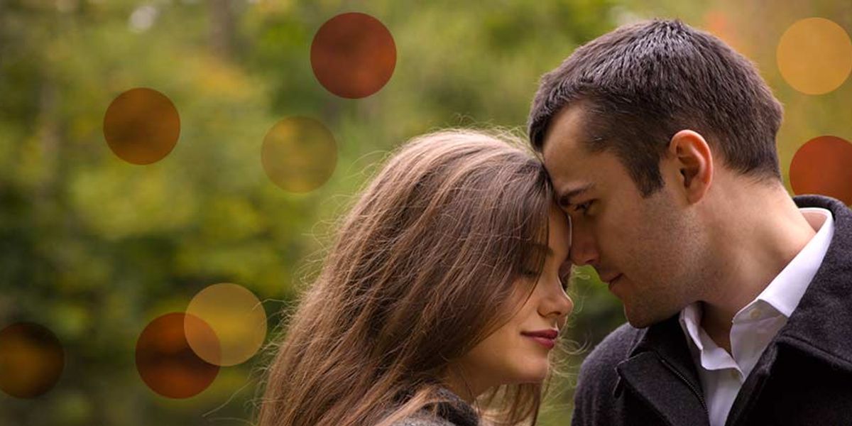 Couple touching foreheads in a quiet outdoor setting, sharing an intimate, peaceful moment