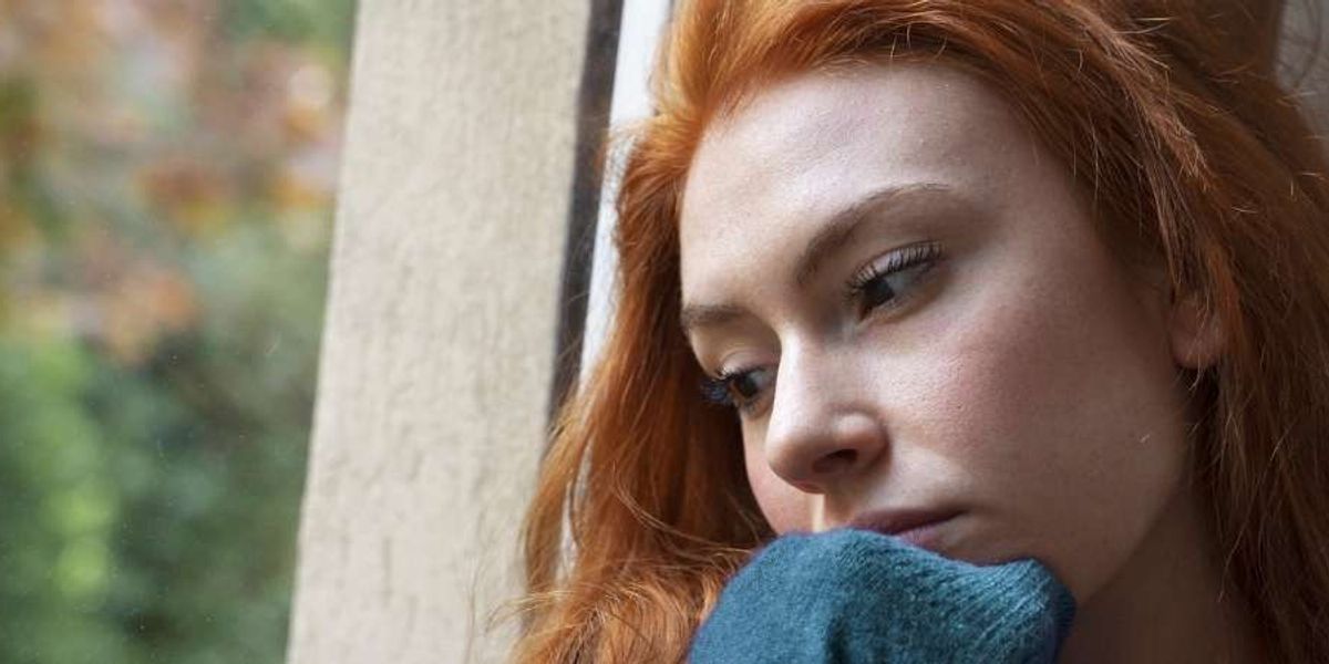 sad woman looking out the window