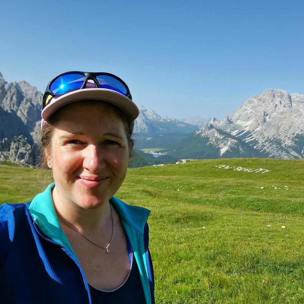 Jane Nizi, founder of Figure Eight Creative, in the outdoors with a backdrop of mountains.