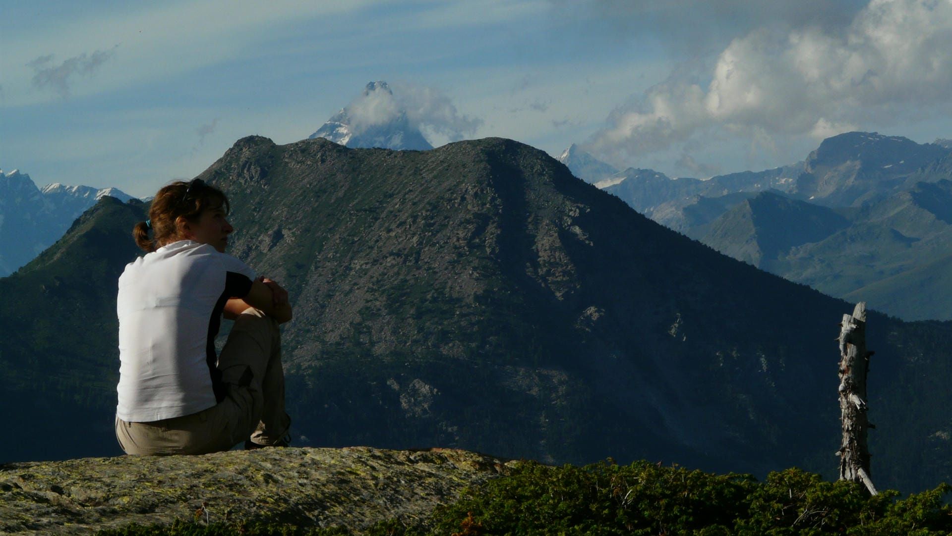 Jane Nizi, founder of Figure Eight Creative, sat on the top of a mountain looking out at the view.