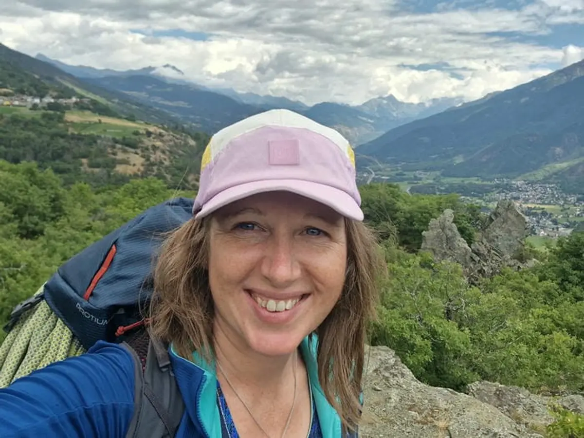 A post-climb smiling selfie of Jane Nizi, founder of Figure Eight Creative, with the Aosta Valley behind her