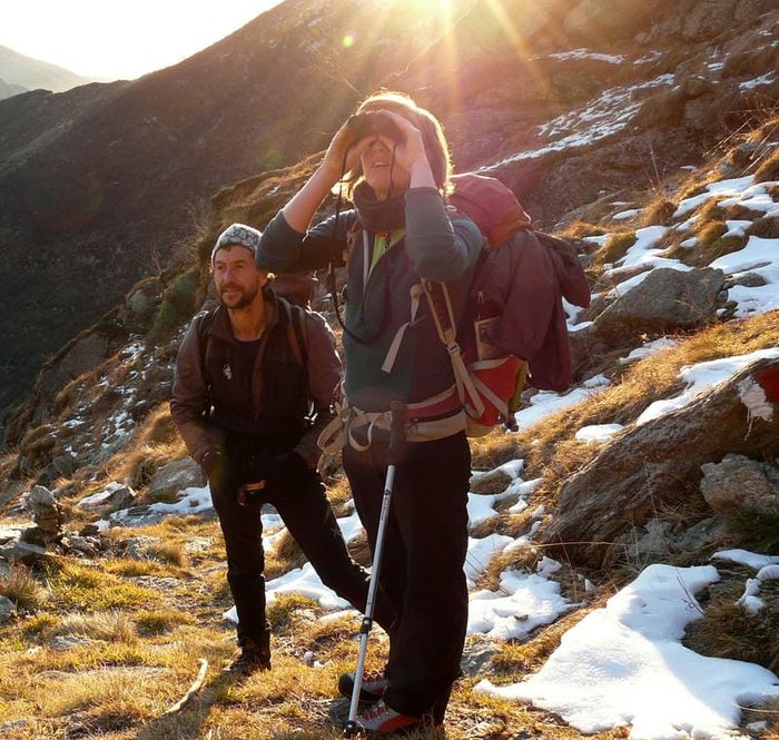 Jane Nizi, founder of Figure Eight Creative, looking out with a pair of binoculars and stood with a friend.