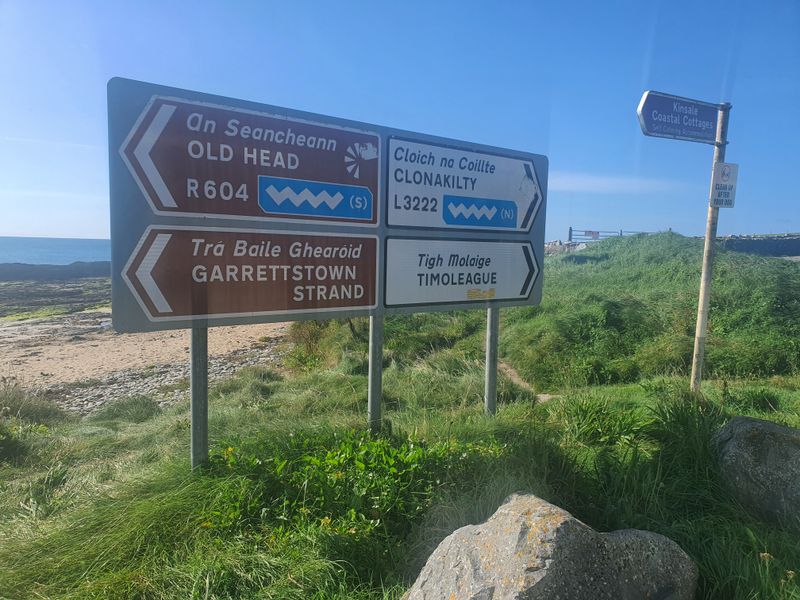 Wild Atlantic Way road signs pointing to Old Head of Kinsale, Garrettstown Strand, Clonakilty and Timoleague