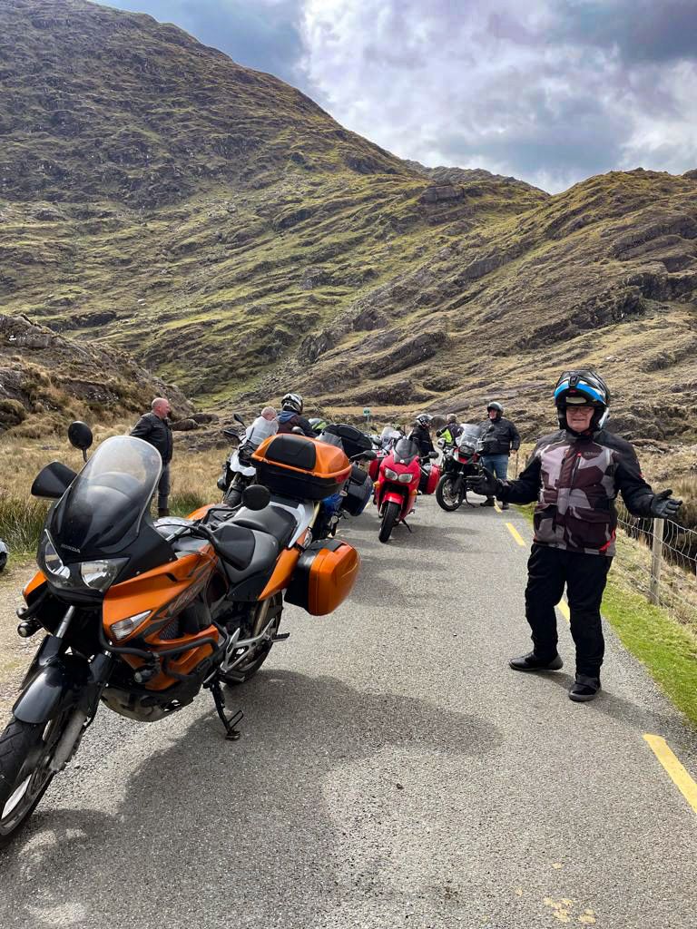 The group pauses on a rocky mountain pass road