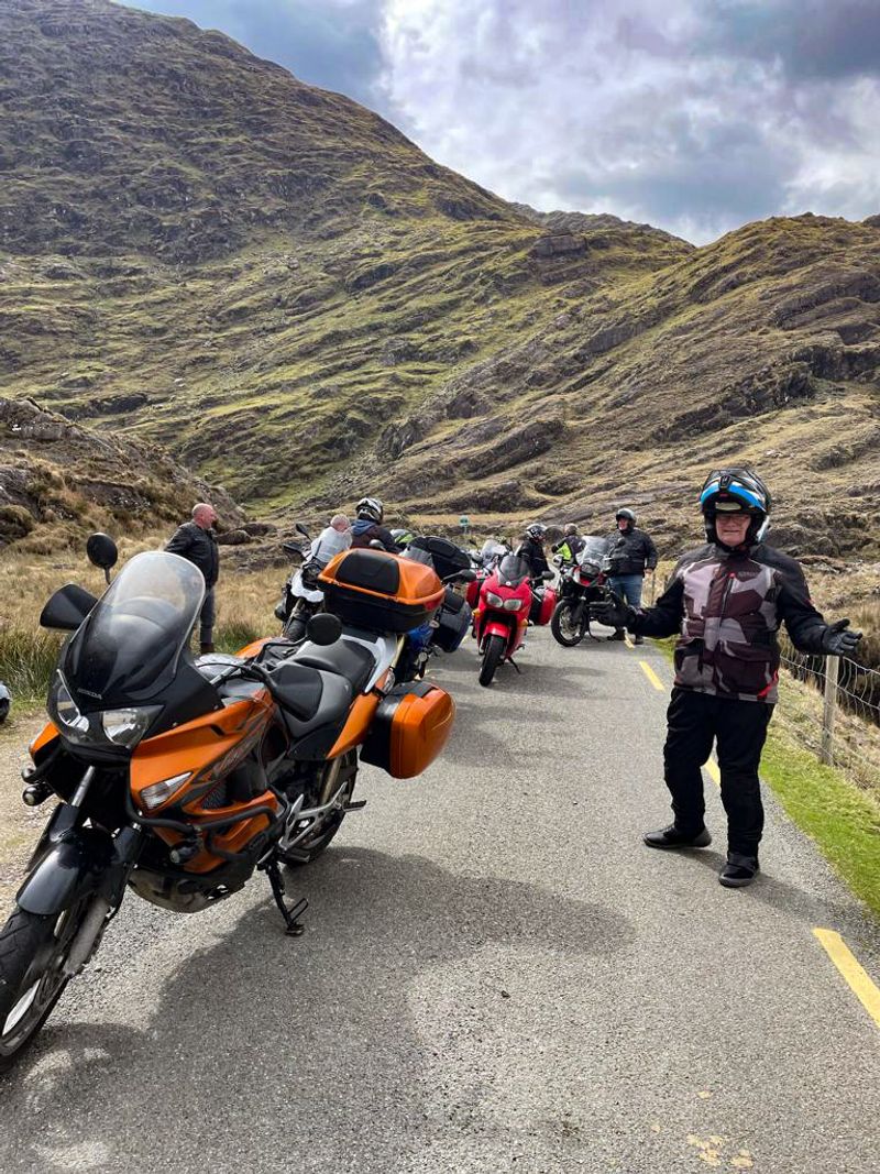 Motorcycle tour group taking a break on a narrow Irish mountain pass road