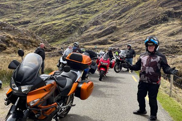The group pauses on a rocky mountain pass road
