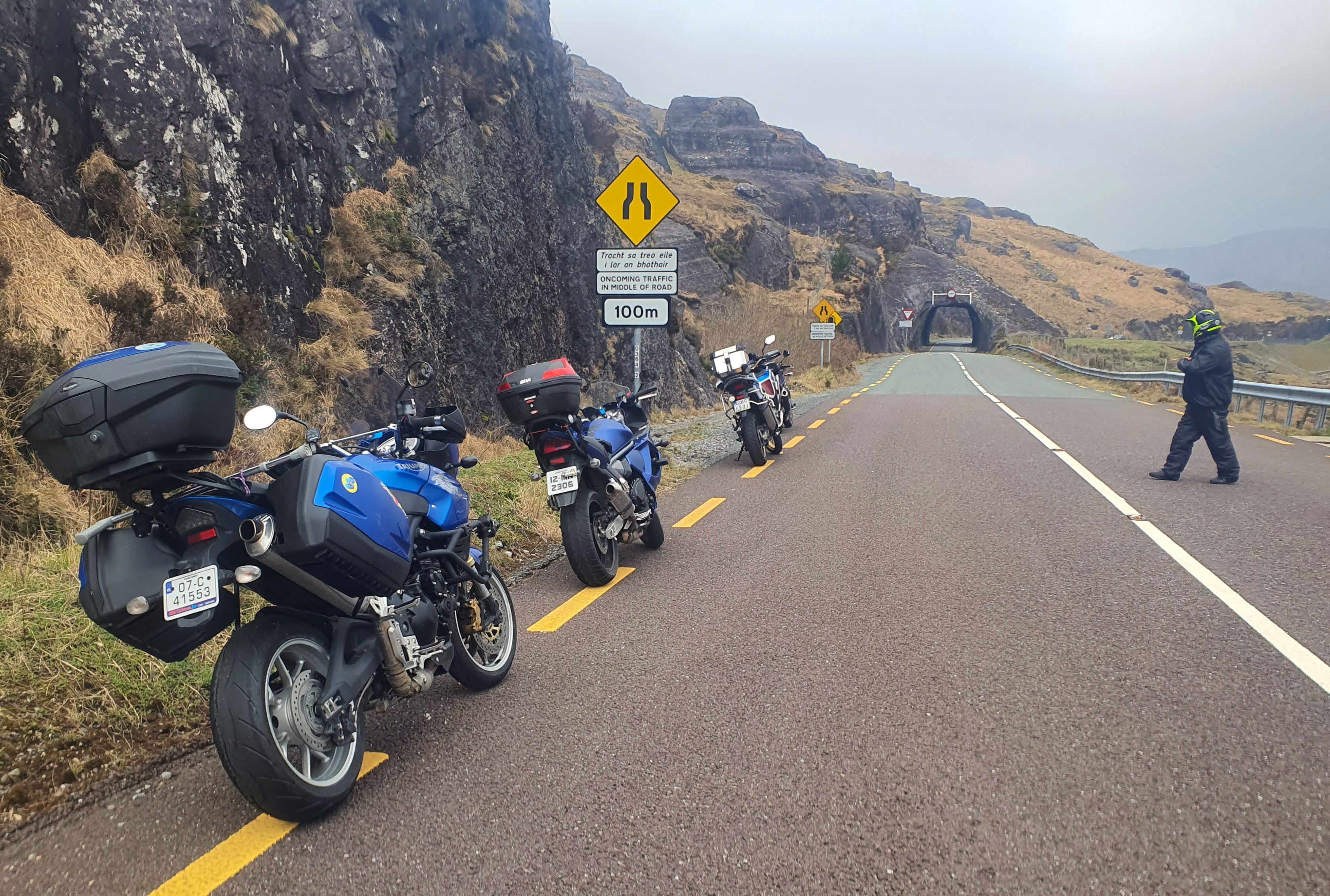 Motorcycles pulled in before the rock tunnels on the Caha Pass